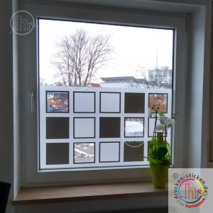 Sichtschutz kombiniert aus Milchglasfolie und farbiger Plotterfolie. Ein Blick nach draußen ist durch ausgelassene Quadrate möglich.